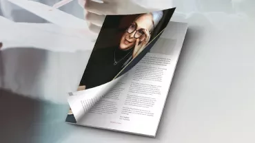 Primer plano de una revista con una figura leyendo.