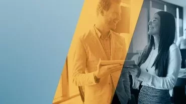 Dos personas conversando alegremente en una oficina.