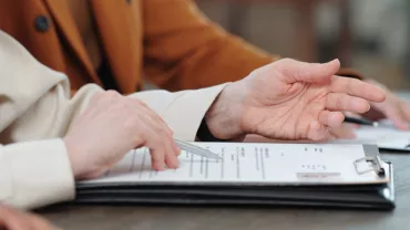 Personas revisando documentos en una mesa.