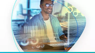 Hombre trabajando en computadora con gráficos digitales superpuestos.