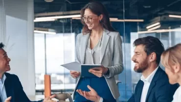 Reunión corporativa en oficina moderna con equipo de trabajo y dispositivos digitales