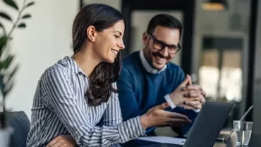 Trabajo colaborativo con computadora portátil en entorno de oficina moderna