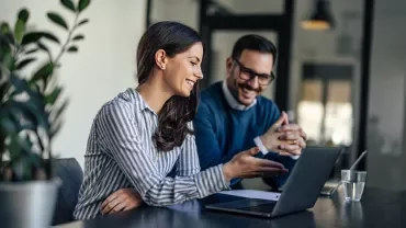Trabajo colaborativo con computadora portátil en entorno de oficina moderna