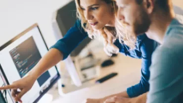 Dos personas trabajando frente a una computadora.
