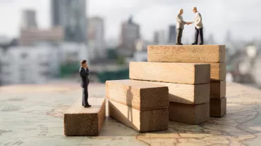 Figuras de personas sobre bloques de madera, simbolizando el éxito empresarial.