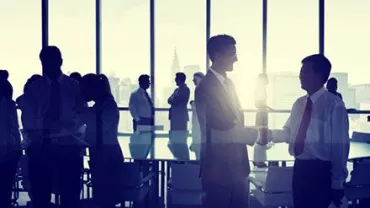 Personas en una reunión de negocios, dándose la mano.