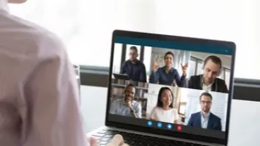 Persona participando en una videollamada de seis personas en laptop.