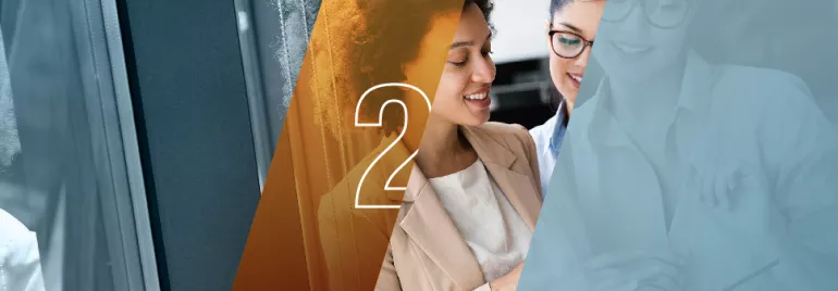 Dos personas sonríen y miran un dispositivo.