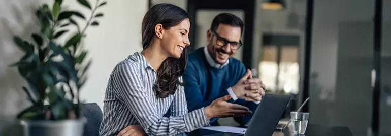 Trabajo colaborativo con computadora portátil en entorno de oficina moderna