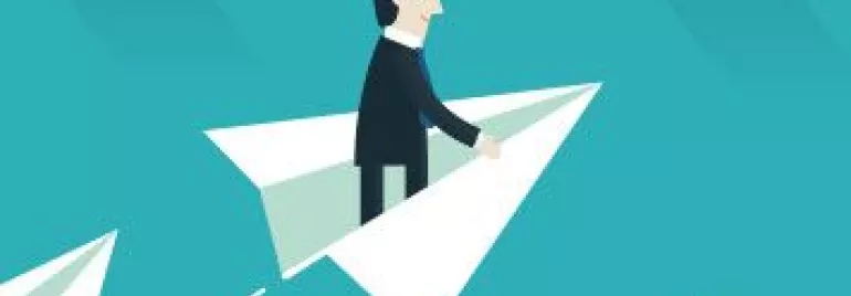 Hombre en traje volando en un avión de papel sobre un fondo azul.