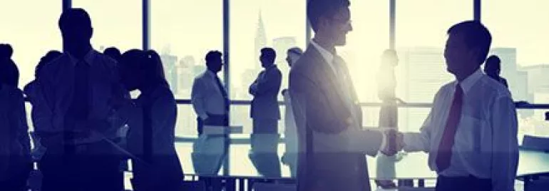 Personas en una reunión de negocios, dándose la mano.