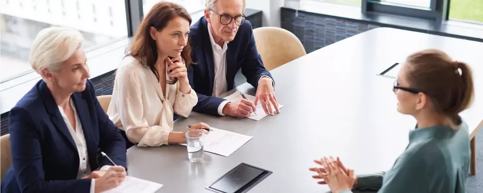 Entrevista laboral con tres personas evaluando a una candidata.