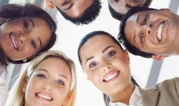 Grupo de personas sonriendo visto desde abajo.