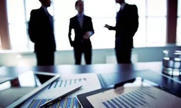 Reunión de negocios con gráficos en la mesa.
