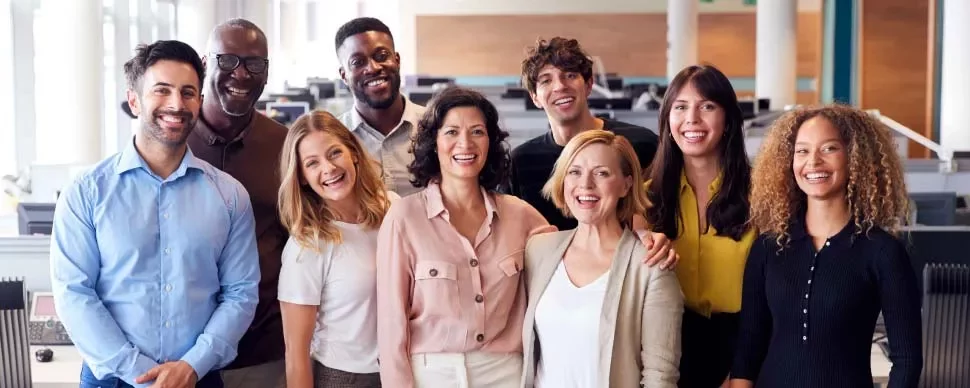 Grupo de personas sonrientes en una oficina moderna.
