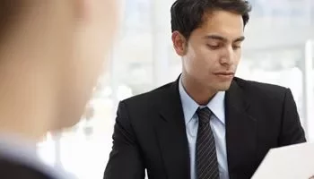 Hombre en traje revisando documentos en la oficina.