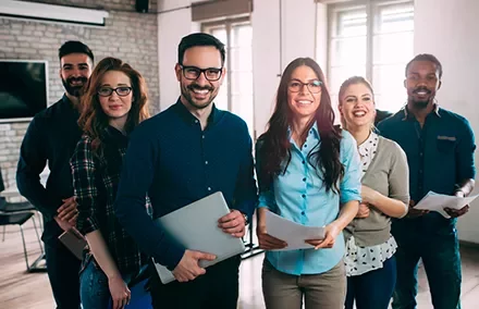 Grupo de personas sonriendo en una oficina moderna.