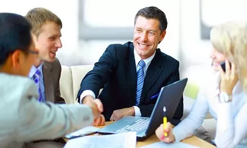 Personas en una reunión de negocios estrechando manos.