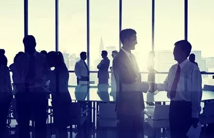 Personas en una reunión de negocios, dándose la mano.